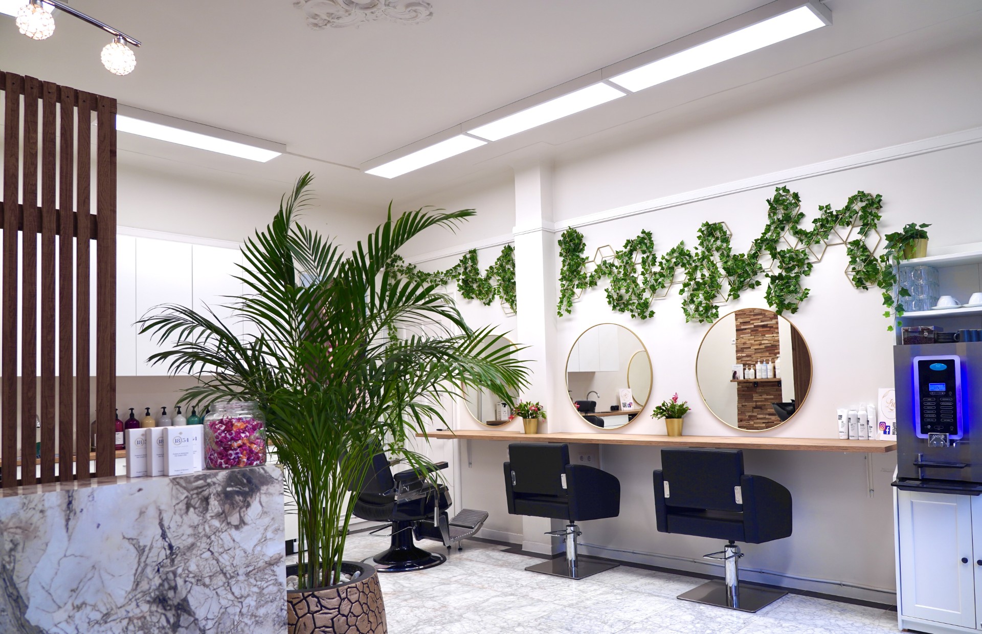 De salon van Lux Hairstyle met gouden spiegels en kappersstoelen